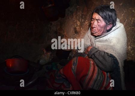 Indische Frau, 80 Jahre, sitzen in ihrer Hütte, Anden, Grenzgebiet zwischen Bolivien und Peru, Südamerika Stockfoto