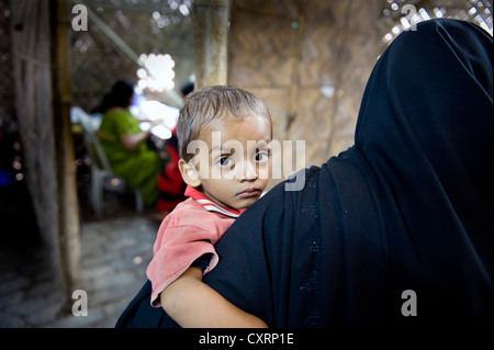 Frau mit einem Kind auf dem Arm von der Hilfsorganisation "Machte Fuer Die Dritte Welt", in einer Bambushütte eingerichteten Klinik Deutsch Stockfoto