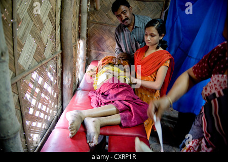 Patienten liegen auf einem Trolley oder Gurney, Einrichtung Klinik in einer Bambushütte von der Hilfsorganisation "Machte Fuer Die Dritte Welt" Stockfoto