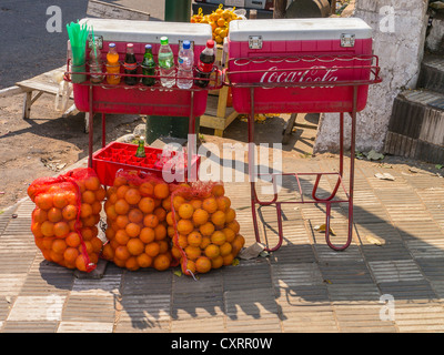 Getränke in Flaschen mit Strohhalmen und große Taschen von Orangen für Verkauf durch Straßenhändler in Asunción, Paraguay. Stockfoto