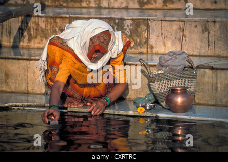 Frau bei einem Morgengebet oder Puja, weglegen Öllampe auf den Ganges Ghats, Kashi, Varanasi oder Benares, Uttar Pradesh Stockfoto