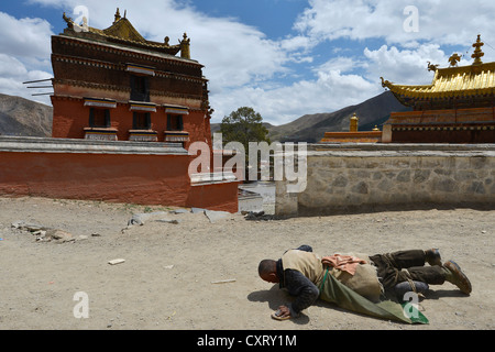 Tibetischen Buddhismus, Niederwerfungen, tibetischen Pilger, eine buddhistische Gläubige auf der Kora Pilgerweg, Labrang Kloster, Xiahe, Gansu Stockfoto