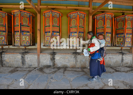 Tibetischen Buddhismus Tibetische Seniorin mit einem kleinen Kind, tragen junge, in einem Tragetuch auf dem Rücken die traditionelle Chuba während Stockfoto