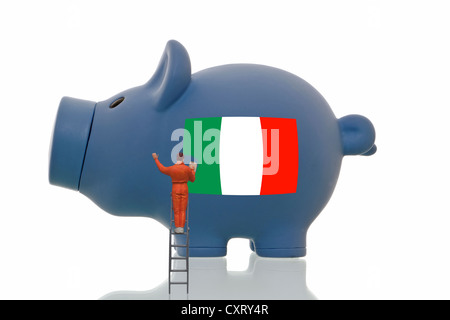 Miniaturmalerei Figur über eine italienische Staatsflagge auf ein blaues Sparschwein, symbolisches Bild Stockfoto