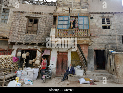 Alten muslimischen Mann mit einem Bart und zwei junge Holzarbeiter an einem alten Schlamm-von Mauern umgebene Haus der Uighuren, Handwerker Straße, Kashgar Stockfoto