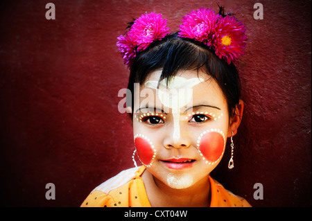 Mädchen mit Blumen im Haar, ist ihr Gesicht gemalt mit Thanaka-Creme, Bagan, Burma, Myanmar, Südostasien, Asien Stockfoto