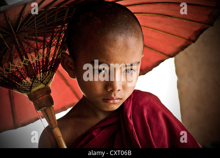 Buddhistische Anfänger hält einen Regenschirm, Bagan, Burma, Myanmar, Südostasien, Asien Stockfoto