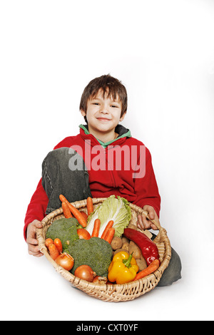 Junge hält einen Korb mit Gemüse Stockfoto