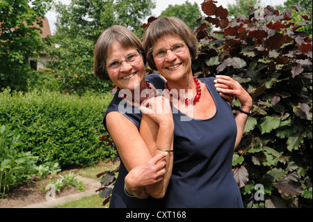 Lüsterne Zwillingsschwestern, gleich gekleidet, portrait Stockfoto