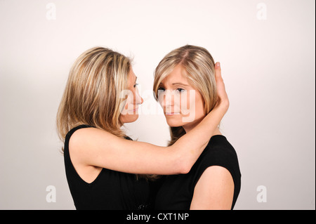 Zwillingsschwestern umarmt, eine Schwester, die andere Schwester trösten Stockfoto