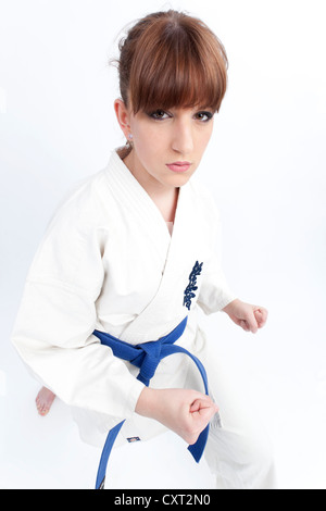 Junge Frau in einem Karate-Gewand mit einem blauen Gürtel, bereit zu kämpfen, kämpfen Haltung Stockfoto