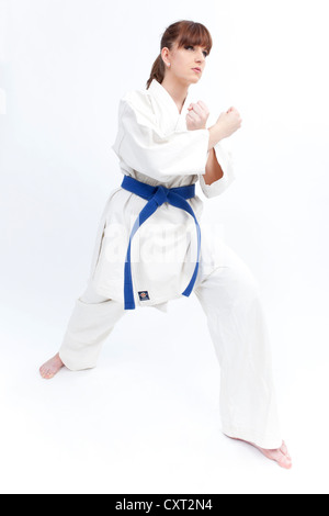 Junge Frau in einem Karate-Gewand mit einem blauen Gürtel, bereit zu kämpfen, kämpfen Haltung Stockfoto