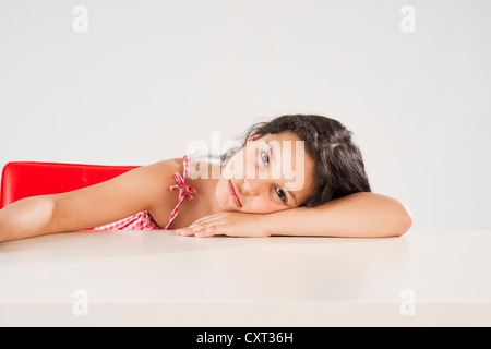 Mädchen sitzen an einem Tisch, Langeweile Stockfoto