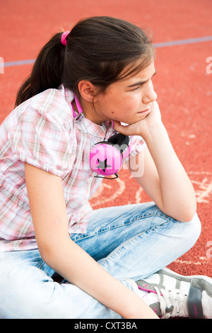 Mädchen sitzen gelangweilt auf dem Schulhof Stockfoto