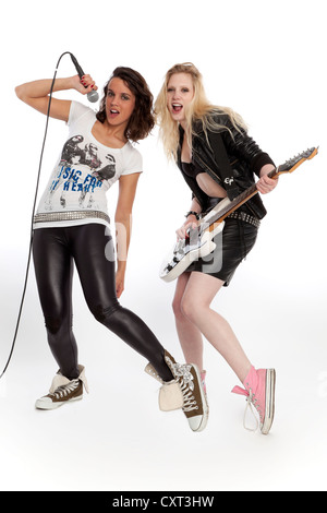 Zwei junge Frauen rocken mit einer Gitarre und ein Mikrofon Stockfoto