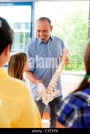 Ein Modell der Wirbelsäule vor einer Klasse von Schülerinnen und Schüler Lehrer Stockfoto