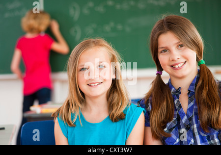 Porträt von zwei Schülerinnen in einem Klassenzimmer vor der Tafel Stockfoto