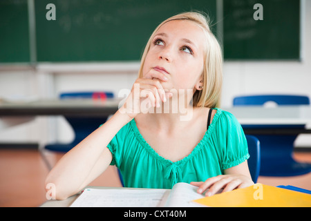 Schulmädchen in einem Klassenzimmer zu sitzen und grübeln über ein problem Stockfoto