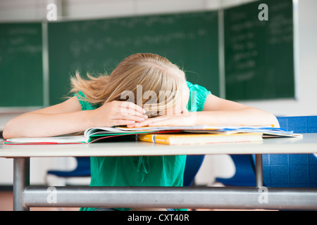 Schulmädchen in einem Klassenzimmer zu sitzen und grübeln über ein problem Stockfoto