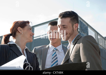 Geschäftsleute sprechen vor einem Bürogebäude Stockfoto