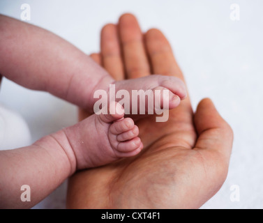 Vater mit den Füßen eines Neugeborenen in den Händen Stockfoto