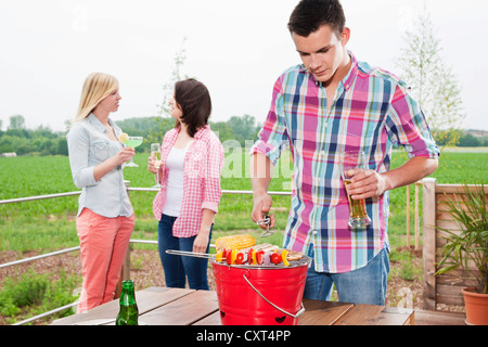 Junge Menschen beim Grillen auf der Terrasse Stockfoto