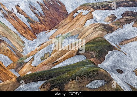 Rhyolith Berge bedeckt teilweise mit Moos und Schnee in Landmannalaugar, Fjallabak Naturschutzgebiet, Island, Europa Stockfoto