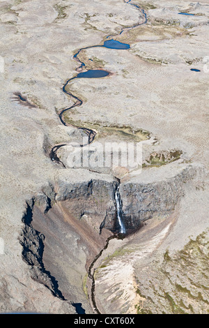 Luftaufnahme, einem mäandernden Fluss mit einem Wasserfall stürzt in eine Schlucht auf einem einsamen Hochplateau im Westen von Island, Europa Stockfoto