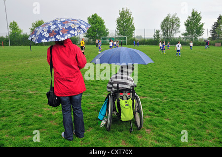 Mutter mit einem Kind im Rollstuhl gerade ein Jugend-Fußball-Spiel, Baden-Württemberg, Deutschland, Europa, PublicGround Stockfoto