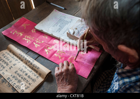 Alte chinesische Mann sitzen an einem Schreibtisch, ethnische Minderheit, üben alte chinesischen Kalligraphie, Nord-Thailand, Thailand Stockfoto