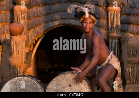 Zulu Mann in traditioneller Tracht spielt Schlagzeug, Film-Set von Shakazulu, Shakaland, KwaZulu-Natal, Südafrika, Afrika Stockfoto