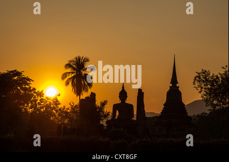 Silhouette der eine sitzende Buddha-Statue bei Sonnenuntergang, Wat Mahathat Tempel, Sukhothai Historical Park, UNESCO-Weltkulturerbe Stockfoto