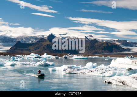 Floß oder aufblasbare Schlauchboot, blaue und schwarze Asche-farbigen Eisberge, Gletscher Lagune von Joekulsárlón, Vatnajoekull Gletscher Stockfoto