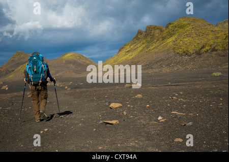 Wanderer in der schwarzen Lava Wüste, mit Moos bewachsenen Berge entlang der Laugavegur Wandern Wanderweg, Álftavatn-Emstrur, Highland Stockfoto