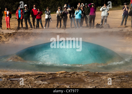 Touristen, die gerade des Strokkur-Geysir ausbrechen, Haukadalur Tal, Golden Circle, Suðurland, Sudurland, Süden Islands Stockfoto