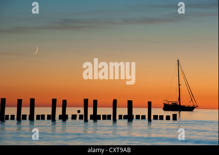 Segelboot, Mond und Wellenbrechern im Abendlicht, Seebad Zingst, Fischland-Darß-Zingst, Ostsee, Mecklenburg Stockfoto