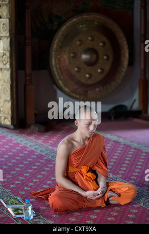 Ein buddhistischer Mönch meditiert in einem Tempel in Luang Prabang, Laos Stockfoto