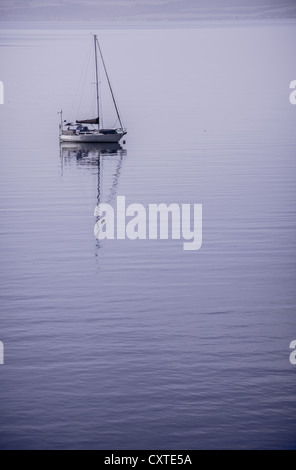 Einsamer Jacht sitzen vor Anker in der schönen noch Wasser bei Sonnenaufgang Stockfoto