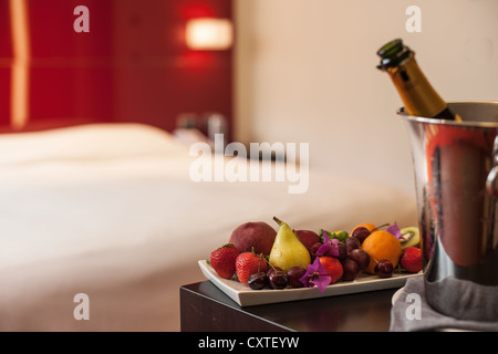 Teller mit Obst und Sekt im Zimmer Stockfoto