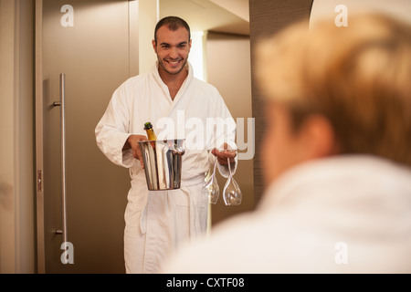 Der Mensch bringt Freundin Champagner Stockfoto