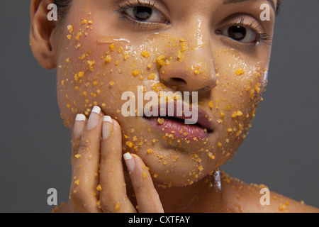 Schöne junge Frau, die Anwendung von Peeling auf Gesicht Stockfoto
