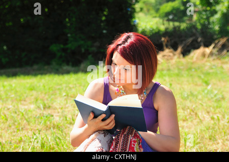 Frau Lesebuch in Rasen Stockfoto