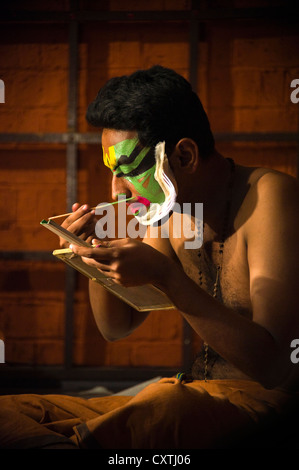 Vertikal nah Porträt des Kathakali-Performance-Künstlers anziehen machen, bevor die Leistung. Stockfoto