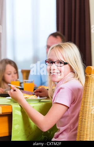 Familie Mittag- oder Abendessen zu essen und am Tisch sitzen Stockfoto