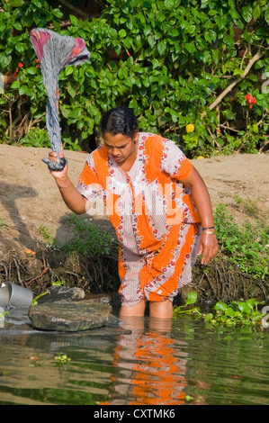 Vertikale Porträt einer indischen Frau die Wäsche am Flussufer in Kerala. Stockfoto