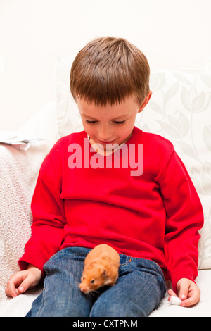 Ein 5 jähriger Junge mit einem Haustier hamster Stockfoto