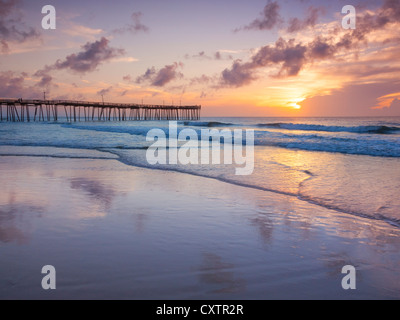 Cape Hatteras National Seashore, Avon, North Carolina Sonnenaufgang und Strand Reflexionen mit Avon Angelsteg in der Ferne Stockfoto