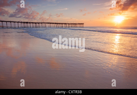 Cape Hatteras National Seashore, Avon, North Carolina Sonnenaufgang und Strand Reflexionen mit Avon Angelsteg in der Ferne Stockfoto
