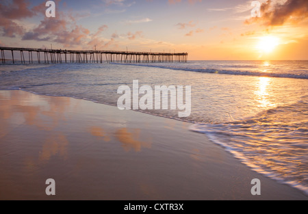 Cape Hatteras National Seashore, Avon, North Carolina Sonnenaufgang und Strand Reflexionen mit Avon Angelsteg in der Ferne Stockfoto
