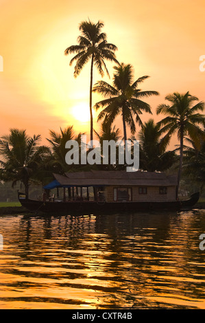 Vertikale Ansicht von einem traditionellen Holzhaus-Boot, Kettuvallam, bei Sonnenuntergang in den Backwaters von Kerala. Stockfoto